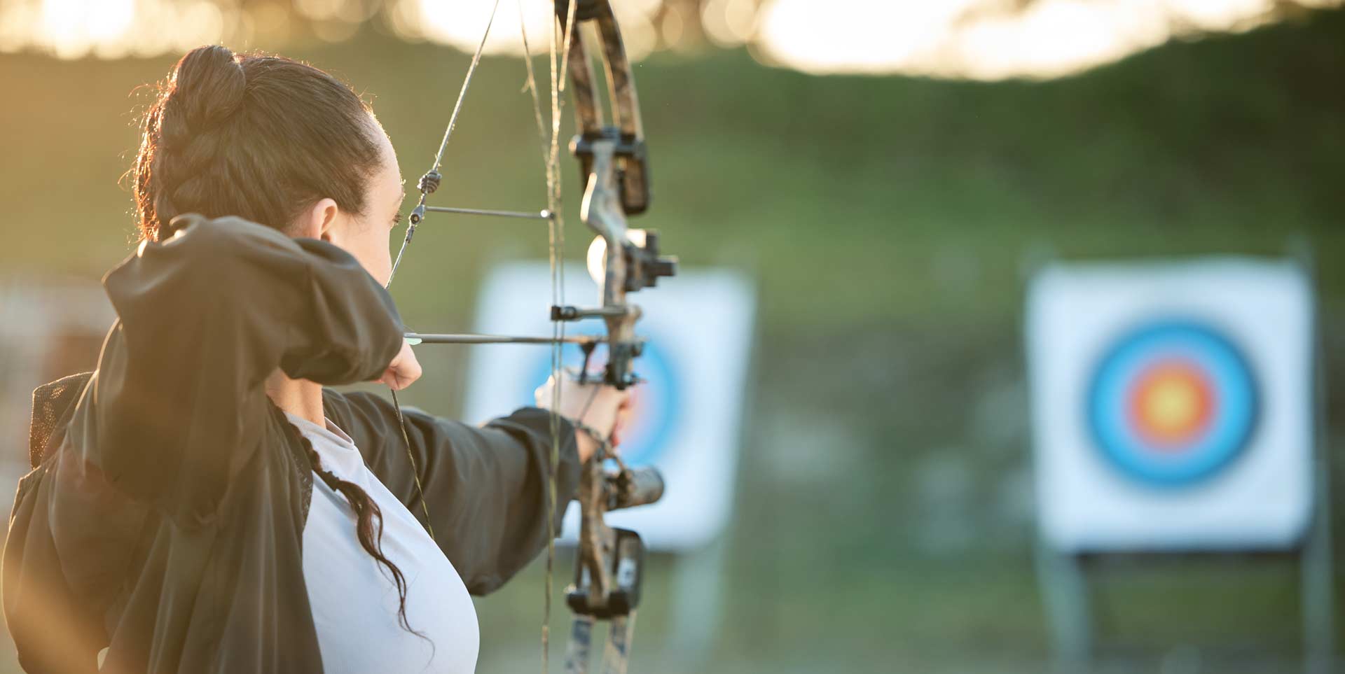 A lady preparing to shoot an arrow with a bow