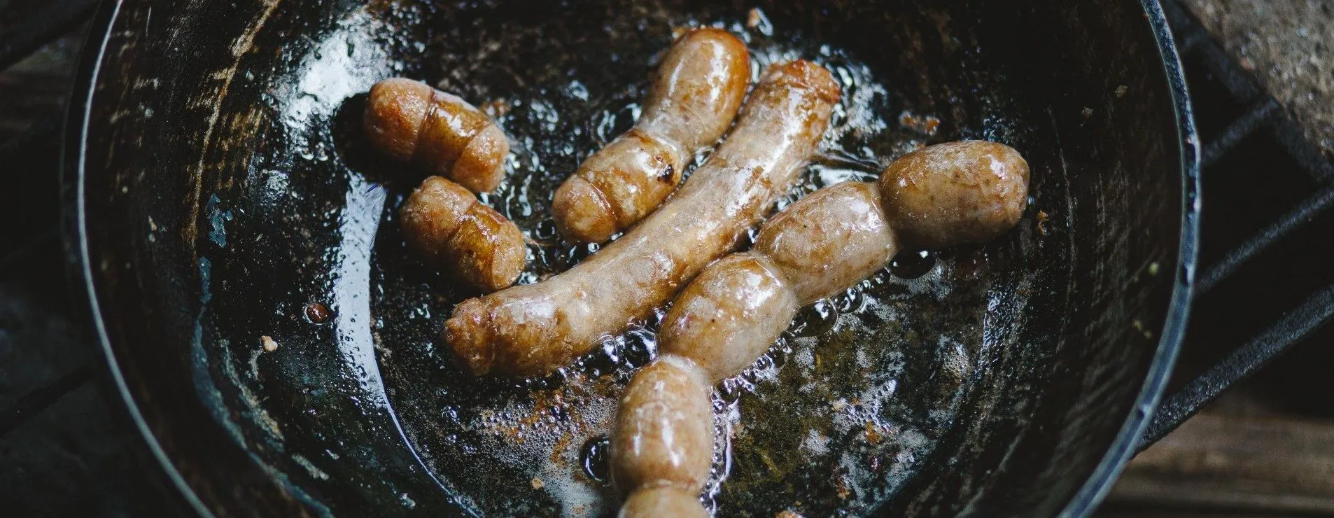 Pork sausages frying in pan